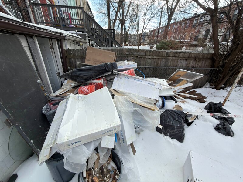 Backyard full of junk and debris before removal